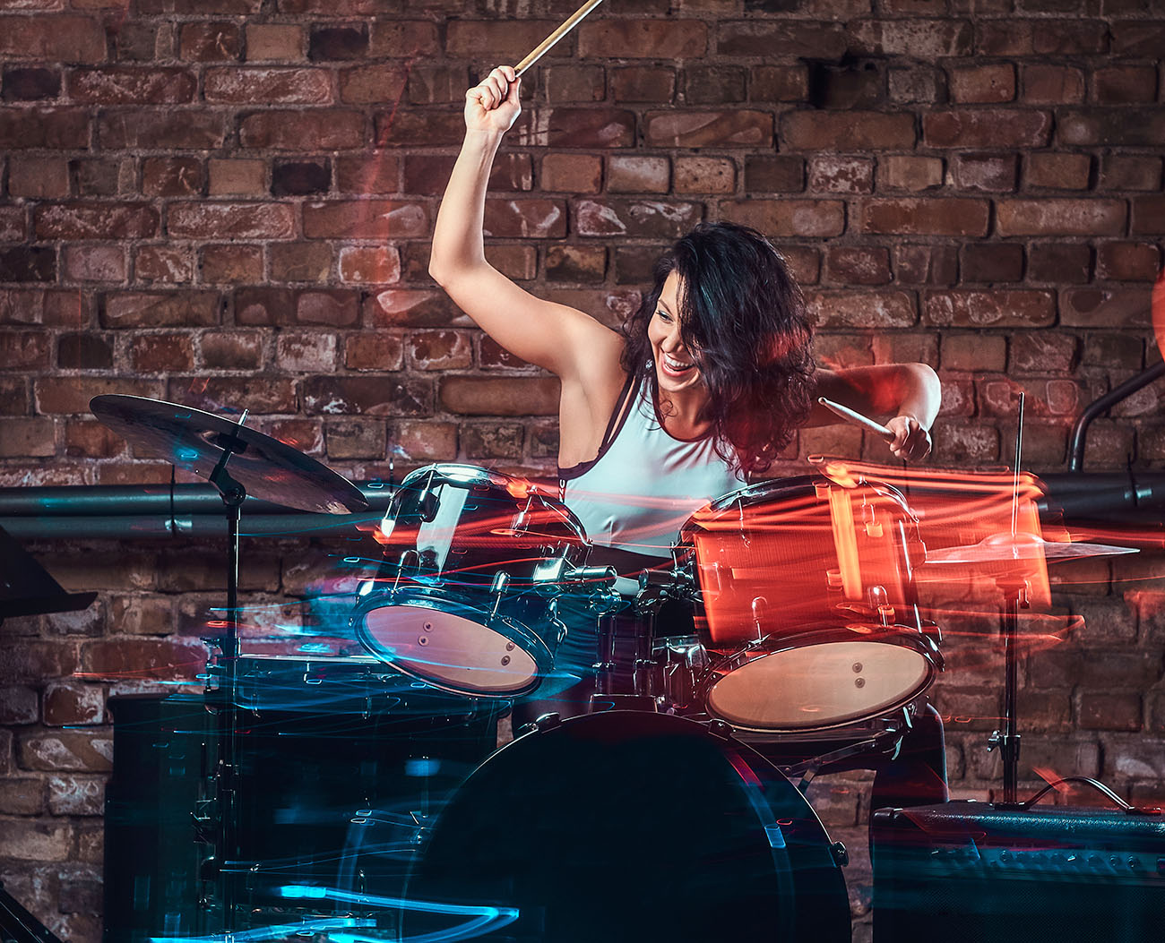 Young girl musician playing on drums and cymbals. Live music in a night club